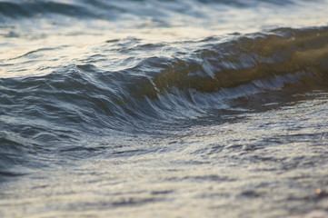 pebble stones on the sea beach, the rolling waves of the sea with foam