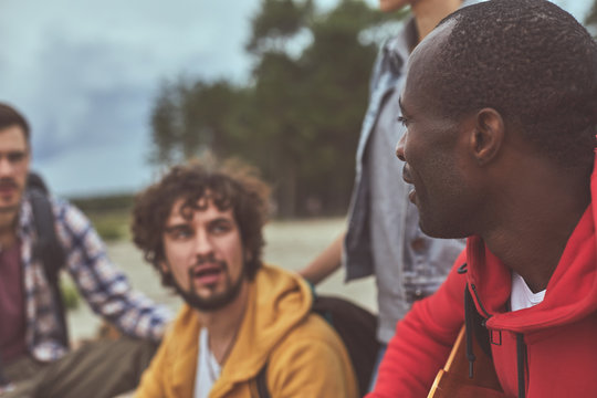 Group of friends. Conversation between two friends during their day off outdoor. Focus on afro man - Powered by Adobe