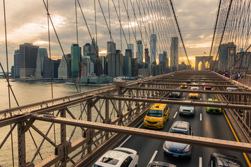 Traffic on Brooklyn Bridge at sunset with Manhattan skyline in the background (New York, USA)