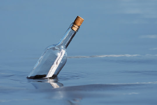 Message in a bottle floating on sea level