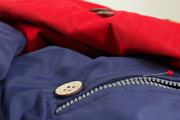 Accessories for sewing on the background of synthetic clothes close up