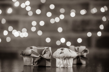 Real homemade classic cupcakes and gift box. Fairy lights and gift box in bokeh background. Christmas time concept