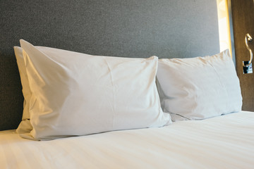 Fototapeta na wymiar White pillow on bed decoration in bedroom interior