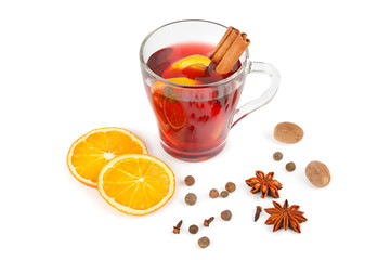 Hot red mulled wine isolated on white background with spices, orange slice, anise and cinnamon sticks.