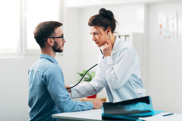 Fototapeta premium Woman Doctor Performing Stethoscope Check Up