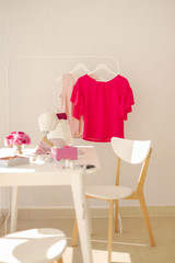 Workplace for sewing and needlework in a bright room with white furniture.