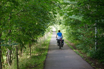 Lonely cycle tourist on the scenic countryside road in Denmark - island Mon.