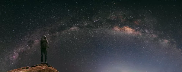  Nachtelijke hemel vol sterren en melkweg, met reiziger met rugzak die & 39 s nachts geniet van een prachtige lucht © SasinParaksa