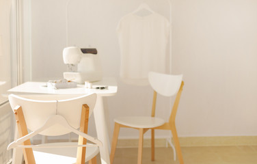 Workplace for sewing and needlework in a bright room with white furniture.