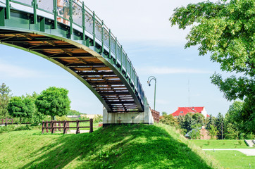 Arched bridge between two green hills