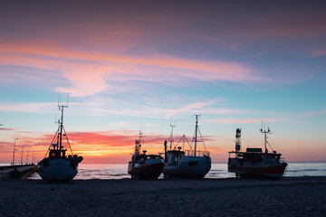 Cute small fishing boats lying on the danish beach at colorful sunset creating a perfect scandinavian summer vacation memory. Løkken in North Jutland in Denmark, Skagerrak, North Sea