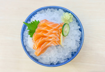 Salmon sashimi on ice serve with fresh wasabi and carrot slide, Japanese food style. Top view with copy space and text