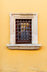 Obraz premium Small window with a metal grille in an old house