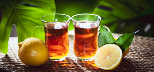 Fruits tea made from Limon , organic tea , fresh limon fruits whole and half on a natural tropical background.