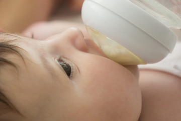 baby infant eating milk from bottle, 9 months after birth