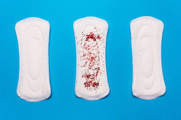 three menstrual pads on a blue background. Concept   menstruation