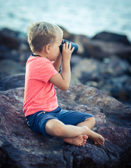 Little boy looking far away with binoculars