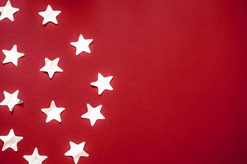 shiny confetti stars in silver colour on a red background