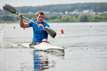 Athletic young rower with oars in a canoe, he training before competition © Seventyfour