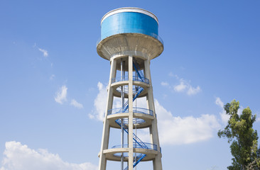 Water tower painted blue under blue sky