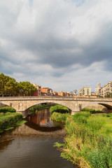 Fototapeta premium old bridge in Girona on the background of a stormy sky