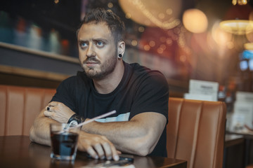 Young attractive man waiting for his meal at cafe.