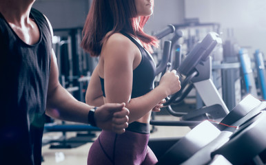 Young peoples training on treadmill at the gym. In fitness center.