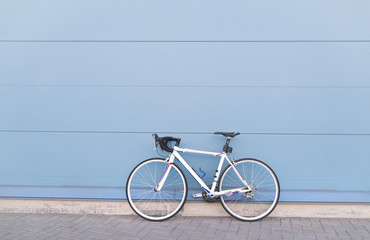 White highway bike on a pastel blue background. Sports concept. Copyspace