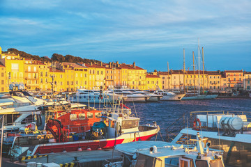 Fototapeta na wymiar Beautiful scenery, view of the old town and the port with boats and yachts in Saint-Tropez at sunset, a trip to the French Riviera Provence in France