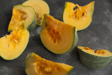 pumpkin, sliced pumpkin, bright orange pumpkin pieces on a dark background