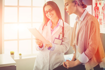 Doctor and patient discussing something while sitting at the table . Medicine and health care...