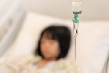 Obraz na płótnie Canvas IV infusion drop with blurred background Asian kid patient child inpatient sleeping on hospital bed .Medical healthcare concept.
