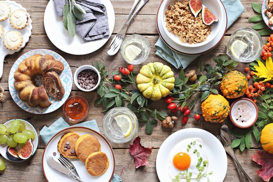 
    Thanksgiving Brunch. Autumn family breakfast or brunch set served on rustic wooden table. Overhead view, copy space