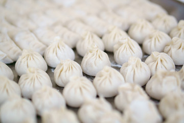 Raw Chinese dumplingson  table, closeup, selected focus. Dumplings are among the most typical food in China