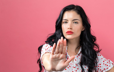 Young woman making a rejection pose on a solid background