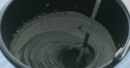 closeup mixing dark gray micro concrete plaster
