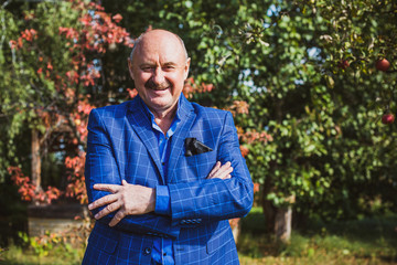 Mature European or American man with a good mood, outdoor portrait. The concept of life after 50-60 years. Positive emotions in senior life. Inspirations in everyday life 