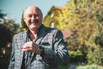 Mature European or American man with a good mood, outdoor portrait. The concept of life after 50-60 years. Positive emotions in senior life. Inspirations in everyday life 