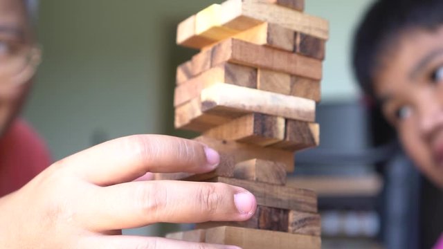 Family hands helping building wooden blocks on tower for plan and strategy in study or business planning generate new ideas concept. 4k slow motion vdo