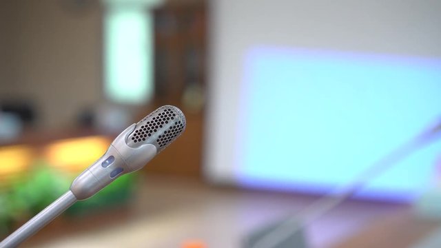 Mini Microphone on abstract blurred conference hall for speaker on stage in seminar room background, Business meeting and education in teaching classroom concept. 4k