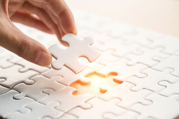 Hand put the last piece of jigsaw puzzle to complete the mission, Business solutions, success and...