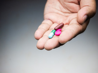 drug capsule pills medical in hand man wood background