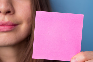 Smiling young casual style woman showing blank pink signboard