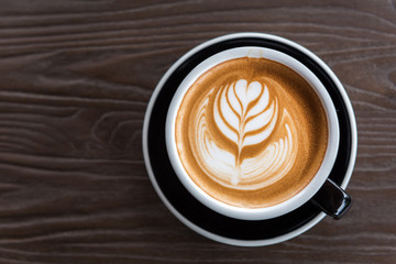 A beautiful cup of Latte art on the wooden space background. Top view, flat lay copy space for your text.