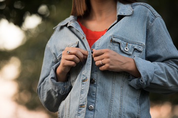 Cropped of unrecognizable woman feeling cold fasten buttons a denim jacket