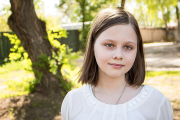 Portrait of a teenage girl, in strict clothing.  The girl in the park