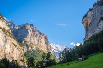 Fototapeta na wymiar Sun is slowly beginning to set on afternoon at the Lauterbrunnen Valley (Berner Oberland, Switzerland). It lies at the bottom of the Lauterbrunnen valley. It is one of the deepest in the Alpine chain.