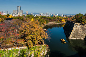 Obraz premium Torist boat at Osaka castle with autumn trees