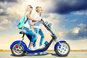 Fototapeta na wymiar Mother and son rides on motorbike.