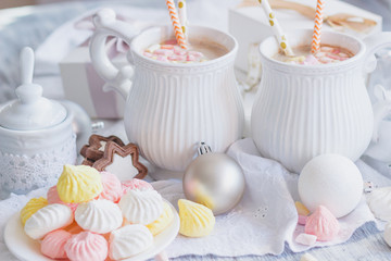 Cups of cacao with marshmallow, meringues and different Christmas decorations